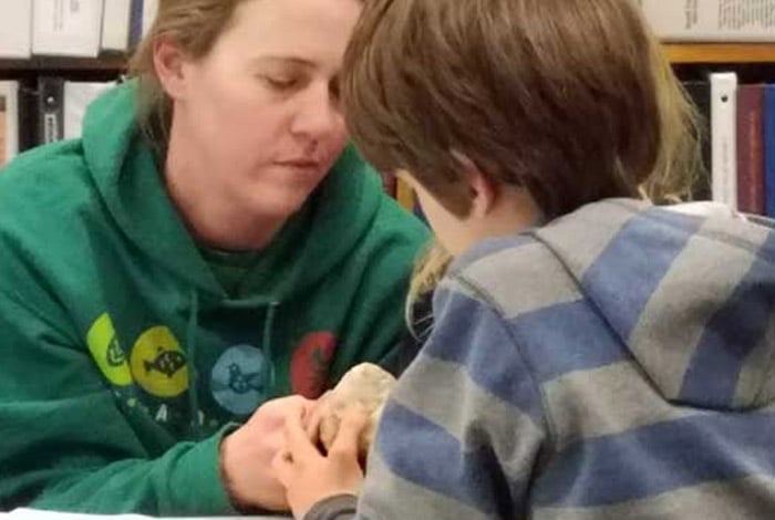 Woman showing object to child